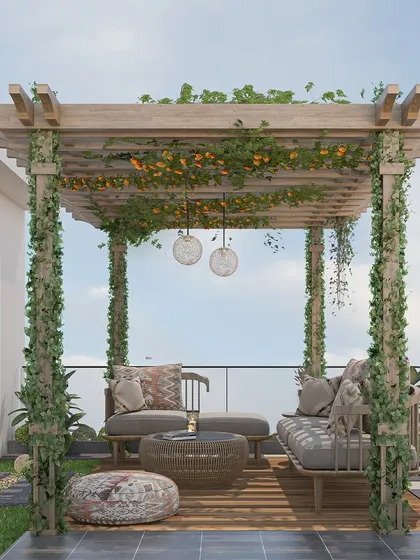 A full view of a charming terrace pergola made from light wood, adorned with climbing plants and flowers. This design creates a beautiful, shaded seating area perfect for enjoying an afternoon outdoors, complete with a comfortable sofa and rattan furniture.