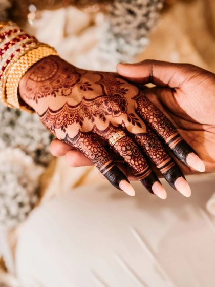 A beautiful couple shot, focusing on the bride's hand and her stunning henna stain.
