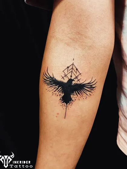 An abstract raven or crow tattoo with geometric elements. The splatter effect gives it a dynamic and modern edge, perfect for a unique statement piece.