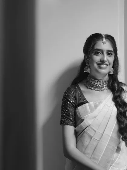 A beautiful black and white portrait of Rashmi. The classic choker and jhumkas stand out, showcasing their timeless design.