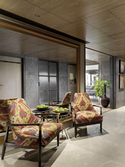 Another view of the Caitriona apartment entrance, where the large gilded mirror reflects the 'Arizona Armchairs', expanding the space and adding a touch of glamour.
