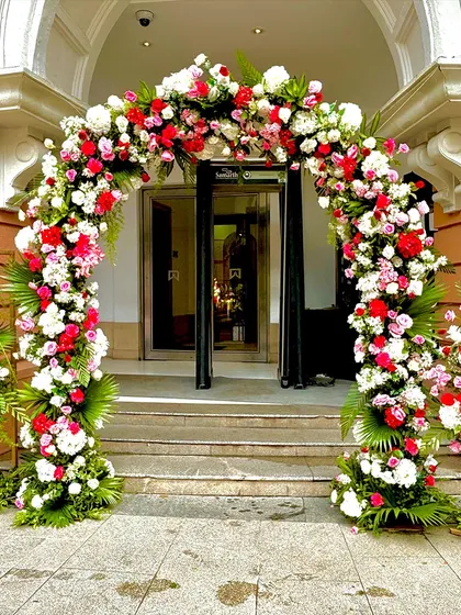 A grand floral arch at the entrance of the venue, packed with beautiful blooms to create a stunning first impression for the wedding guests.