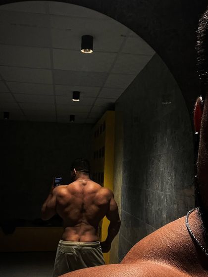 An artistic back shot in the mirror. The lighting highlights the definition and separation in the back muscles.