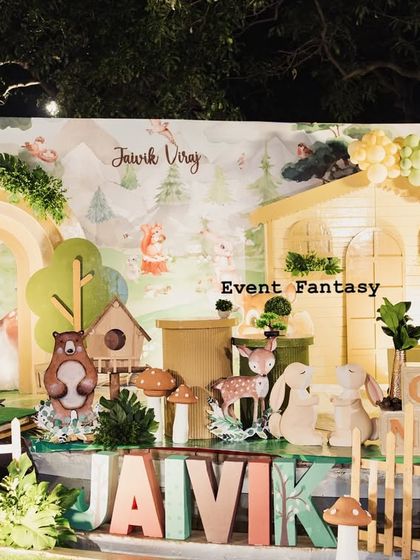 Jaivik Viraj's charming woodland birthday stage. This setup is filled with character, featuring a picket fence, large name blocks, and a variety of friendly woodland animal cutouts like foxes, bears, and raccoons.