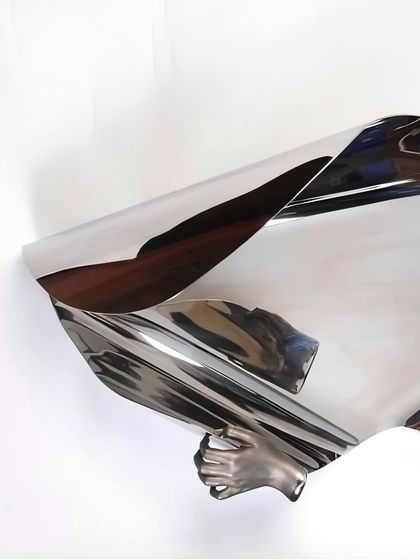 Another angle of "The Power of Being," showing the hand grasping the fluid metal form.