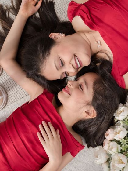A beautiful overhead shot of a mother and daughter lying down together, sharing a moment of love.