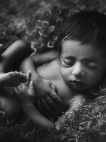Nestled in soft, curly wool, this baby is the picture of comfort and serenity. Black and white enhances the textures and the peaceful mood.