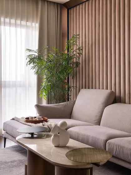 A cozy nook in the living room, perfect for curling up with a cup of coffee and a good book. The fluted wall paneling adds texture and warmth, while the large window offers beautiful views of Old Bengaluru.