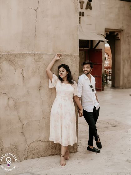 A candid moment of the couple holding hands and smiling, captured in a rustic Dubai setting.