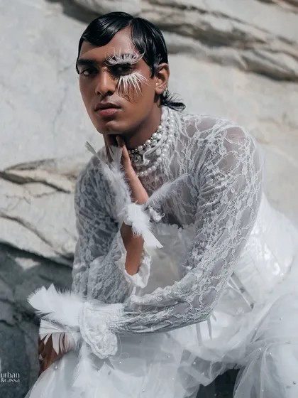 A close-up portrait focusing on the texture of the feathers and the model's direct gaze.