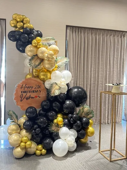 Black, white, and gold is a timeless combination for a fabulous 21st birthday. This balloon sculpture includes tropical leaf accents for a modern twist.