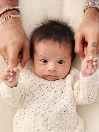 A newborn holds onto their dad's fingers. These are the details that truly matter, showcasing the strength and delicacy of this new connection.