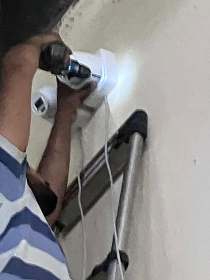 A close-up of the drilling process for a dual-camera mount. We use powerful tools to ensure a solid anchor point.