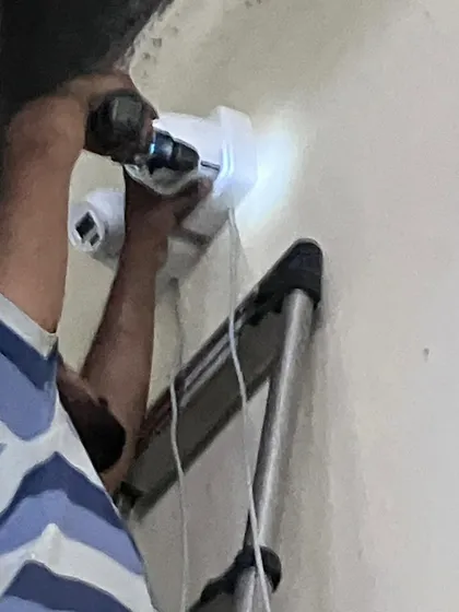 A close-up of the drilling process for a dual-camera mount. We use powerful tools to ensure a solid anchor point.