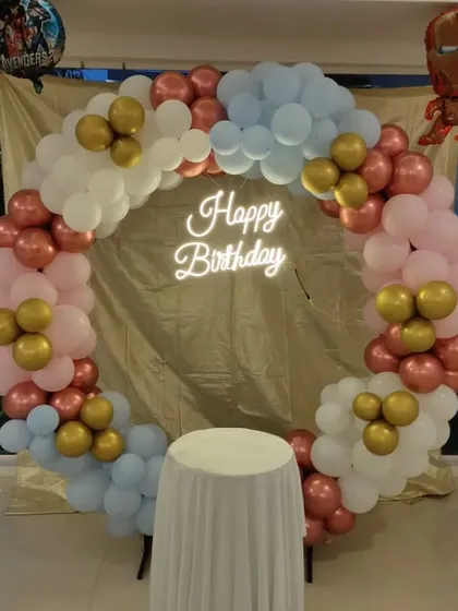 An Avengers-themed circular balloon arch in pastel colors with Iron Man and Avengers foil balloons.