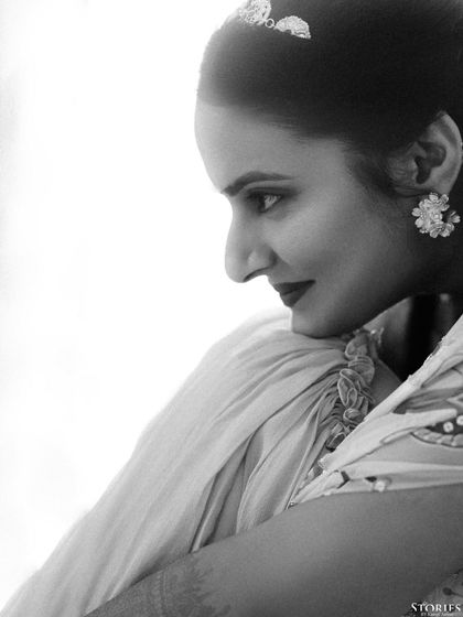 A high-contrast black and white profile of the bride, Sravanthi. This artistic shot emphasizes her features and the delicate details of her attire in a classic, elegant style.