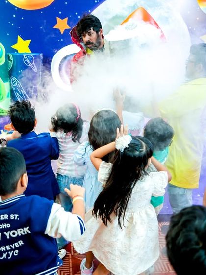 Children reaching out in wonder during a science show, completely captivated by the smoky, mysterious experiment.