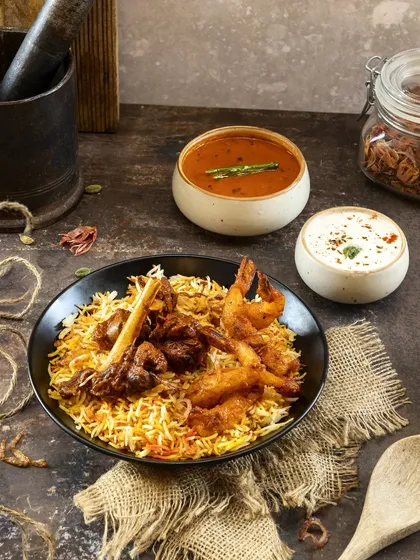A complex dish like biryani requires careful composition. I layered textures with the rustic burlap and dark bowl to create a rich, traditional feel, highlighting the perfectly cooked prawns and mutton for a signature menu item.