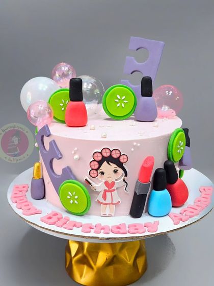 A spa-themed cake for a little girl's party, decorated with fondant nail polish bottles, cucumber slices, and a girl in a bathrobe.