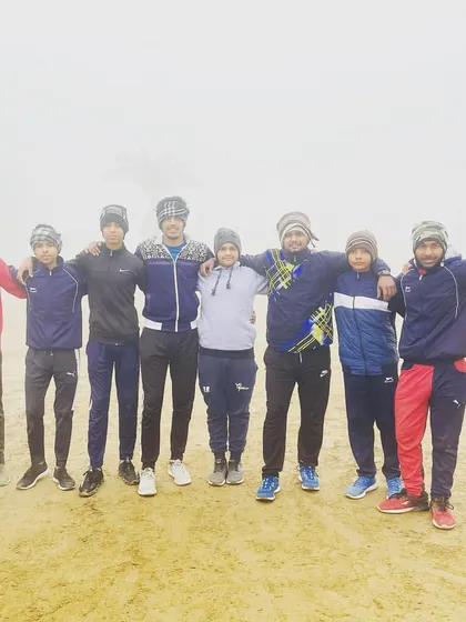 Training continues no matter the weather. The team huddles together for a photo during a cold and foggy winter morning practice.