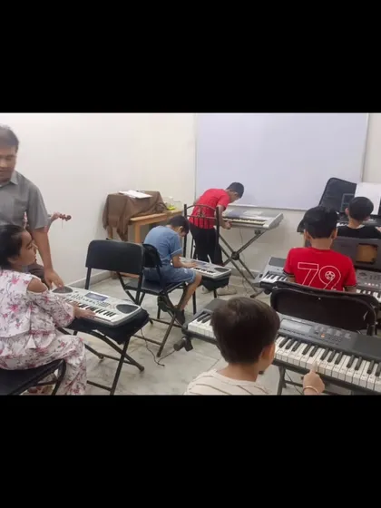 A keyboard class in progress, with an instructor providing one-on-one guidance to a student. We maintain small batch sizes to ensure every child receives personalized attention.