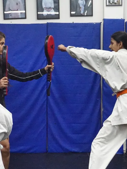 Practice makes perfect. Here, a student in my karate class practices her striking power and precision with pad work, a key drill we use to build both technique and confidence.