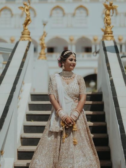 A golden glow for the beautiful bride. She looks absolutely stunning, posing on the steps of a grand location.
