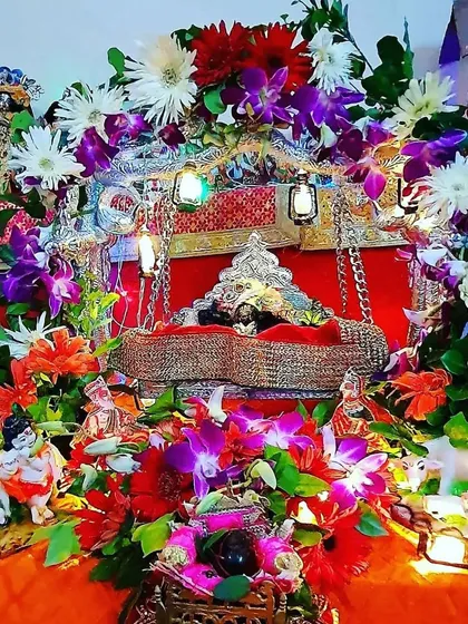 Celebrating the birth of Krishna with a beautifully decorated jhula (swing) for Laddu Gopal. This Janmashtami setup is rich with colorful flowers, small lanterns, and figurines to create a complete scene for the festival.