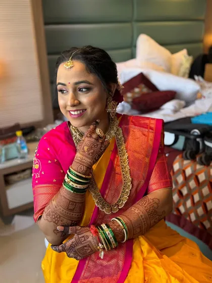 The final look for this Maharashtrian bride, glowing with happiness. Her makeup features soft, defined eyes and a balanced skin finish that looks flawless without feeling heavy, even in a candid, indoor setting.