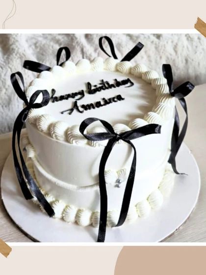 A chic and modern cake with clean lines and delicate black ribbon bows, offering a minimalist yet elegant aesthetic.
