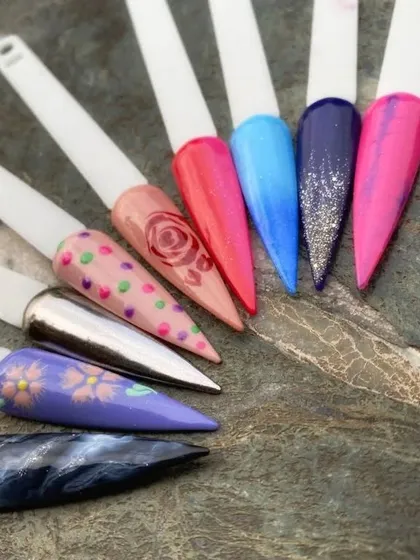 A collection of nail art samples created during a class. This shows the variety of techniques covered, including gradients, polka dots, floral painting, and chrome effects.