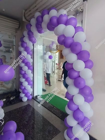 A purple and white balloon arch for a store or office inauguration.