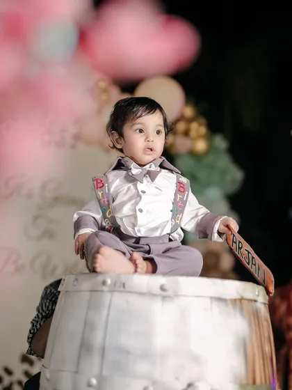 A regal pose from the birthday boy. Sitting atop a barrel, he looks like the king of his circus-themed birthday celebration.