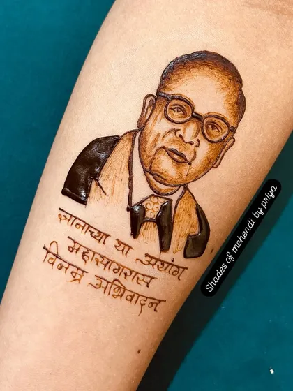 A portrait of Dr. Babasaheb Ambedkar on the forearm, with a quote in Marathi. Creating portraits of respected leaders is an honor, and I focus on capturing their dignified expression.