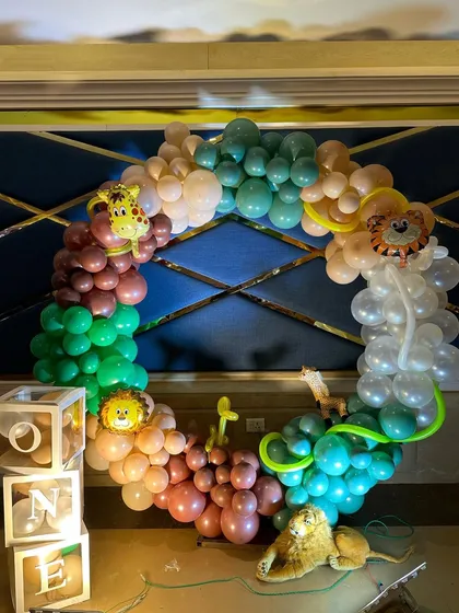 A fun and creative photo booth for the jungle-themed party. We created a circular balloon wreath with safari animal foils and "ONE" blocks for adorable photo ops.