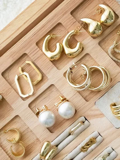A different view of our earring and ring collection, highlighting our pearl studs, triple hoops, and statement heart earrings.