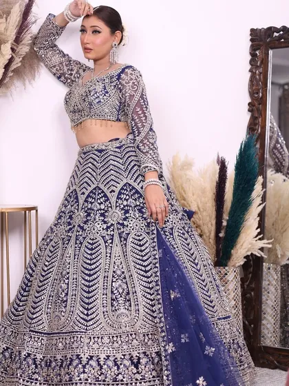 A full-length shot of the deep blue and silver embroidered lehenga, showing the detailed craftsmanship and the beautiful flare of the skirt.