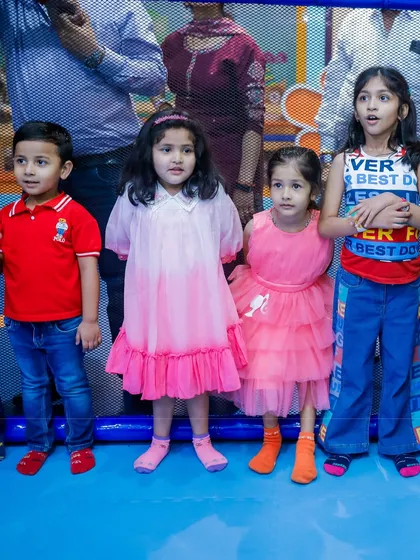 A group of young party guests posing for a picture in the play area.