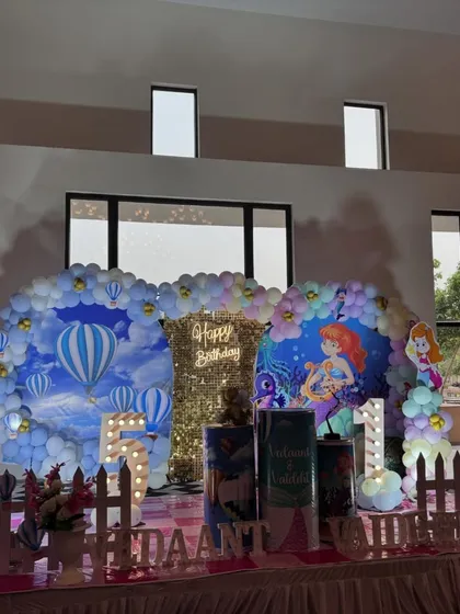 A wider view of the twin-themed party setup, showing the two distinct yet connected backdrops.