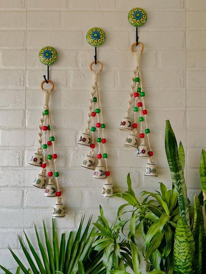 We love working with colorful wooden beads, and this image shows a beautiful display of our 'Symphony Chimes' in the 'Indian Rose' variant. The red and green beads create a festive and vibrant look.