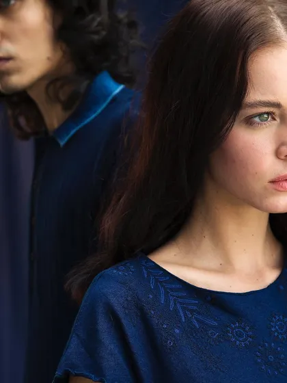 This editorial shot explores connection and distance. The deep blue tones and soft focus create a moody, atmospheric portrait that tells a story without words.