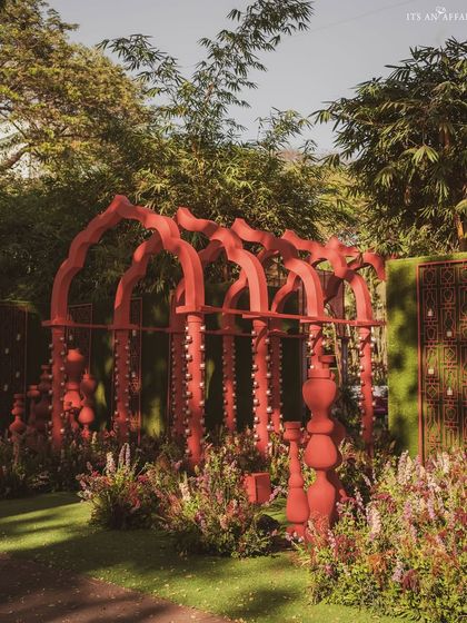 The red architectural structures of 'Gulal Bagh' nestled in a garden, creating a striking visual of art meeting nature.