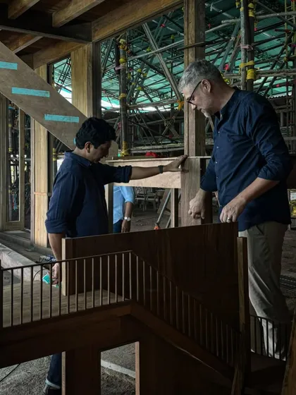 Our principal architect discusses the details of the staircase model with a master carpenter. This direct collaboration between designer and maker is at the heart of our practice.