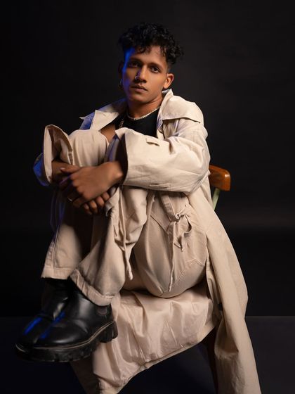 A seated pose from the studio shoot, looking directly at the camera with a relaxed yet focused expression.
