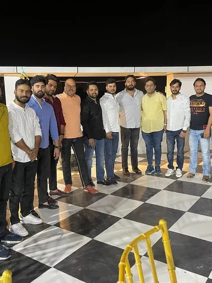 A group photograph on a checkered floor at an evening event. It was a pleasure to meet so many friends from Delhi.