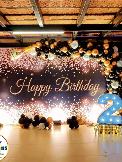 A sophisticated and celebratory theme for a 21st birthday. This design features a sparkling "Happy Birthday" backdrop, a black and gold balloon arch, and champagne bottle props, creating a chic and memorable atmosphere for an adult milestone.