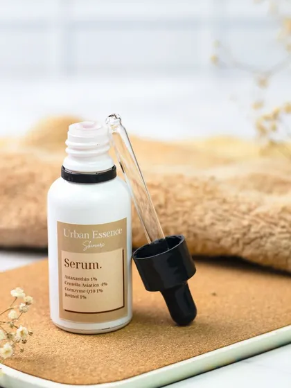 This simple, earthy composition features a serum bottle on a cork surface with delicate dried flowers. The natural textures and warm tones create a feeling of gentle, organic skincare.