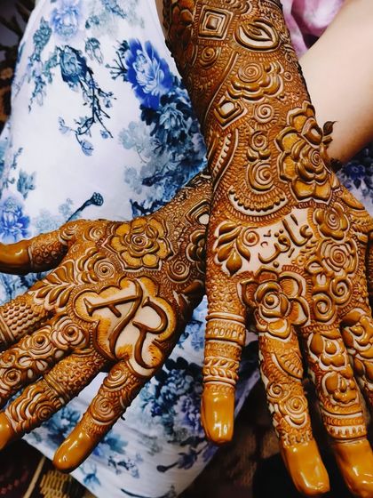 Asbah's mehndi, featuring her and her partner's initials 'AR' and the groom's name 'Aarif' hidden in the design.