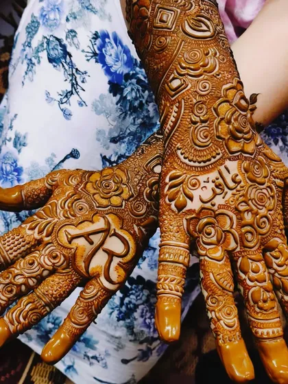 Asbah's mehndi, featuring her and her partner's initials 'AR' and the groom's name 'Aarif' hidden in the design.