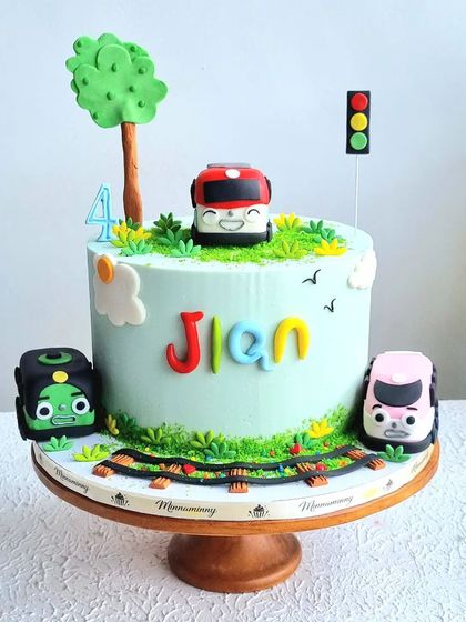 A full view of the Titipo the Little Train cake on its stand.